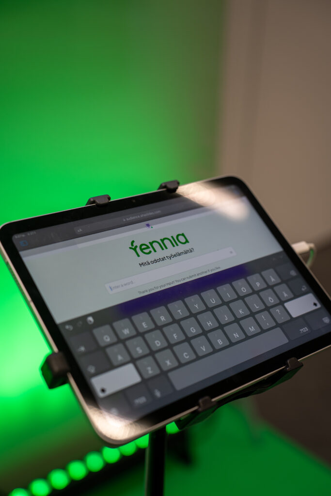 Ipad, jossa auki kysymyssovellus ja Fennian logo